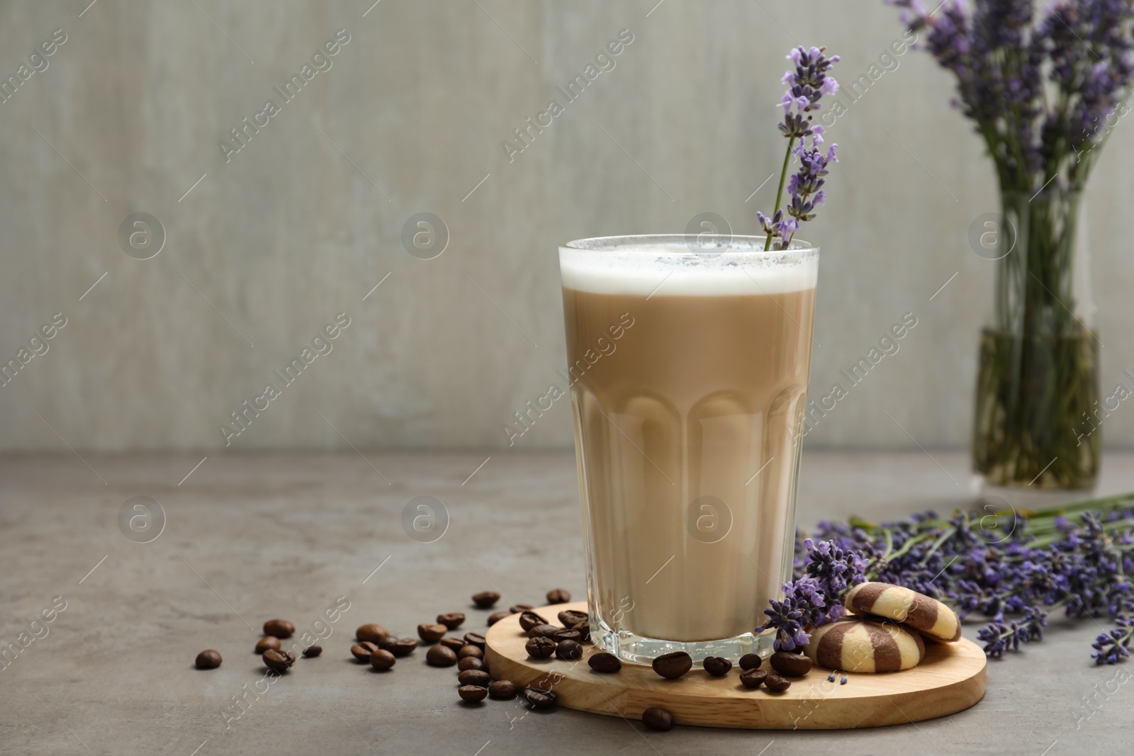 Photo of Delicious coffee with lavender and cookies on grey table. Space for text