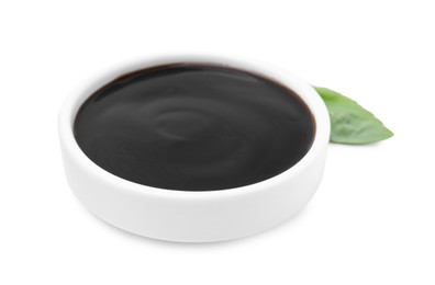 Photo of Balsamic glaze and basil leaf on white background