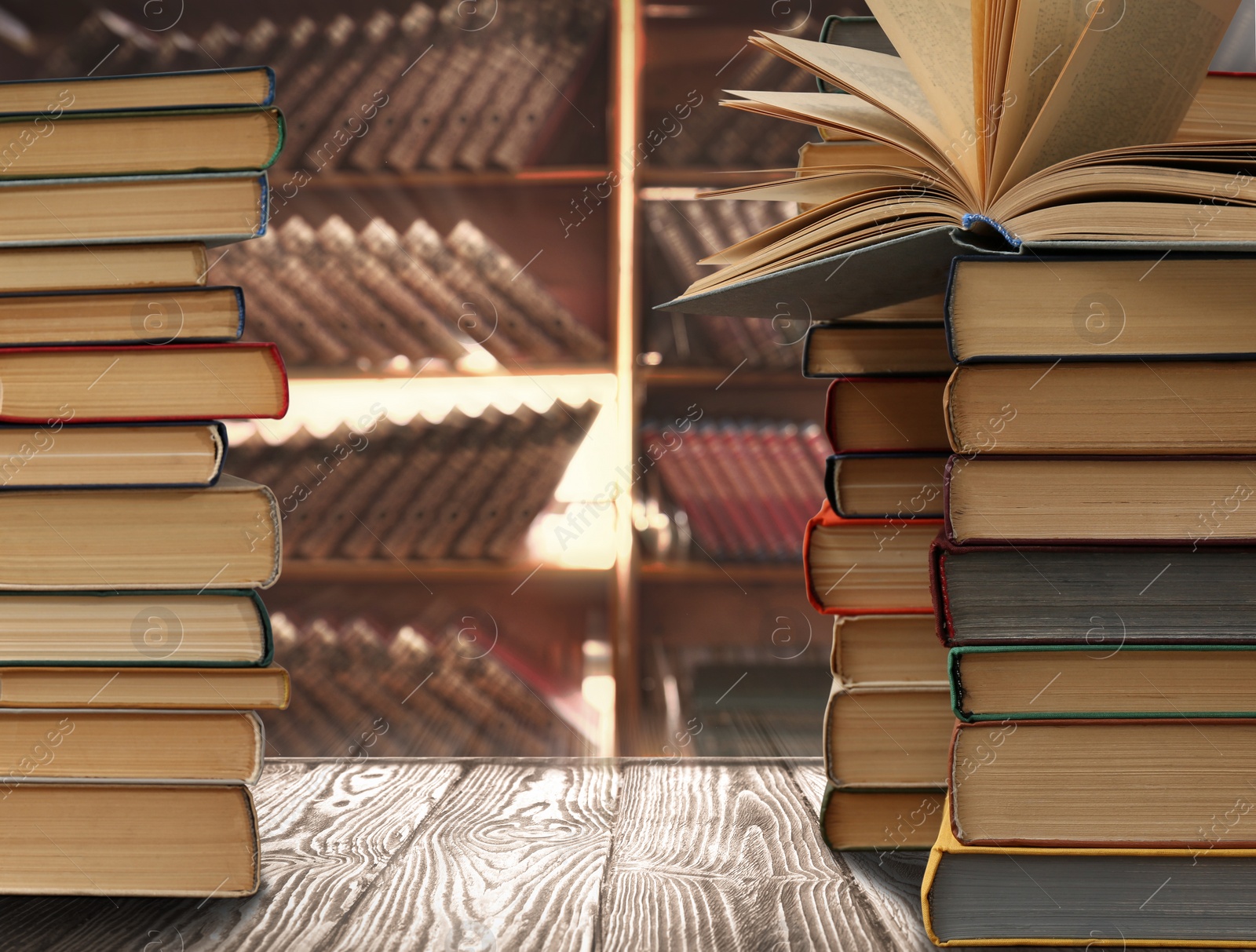 Image of Stacks of different books on wooden table in library