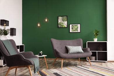 Modern living room interior stylish sofa near green wall