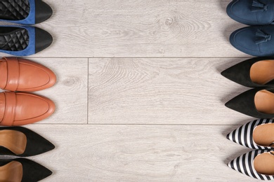 Different female shoes on wooden background, top view