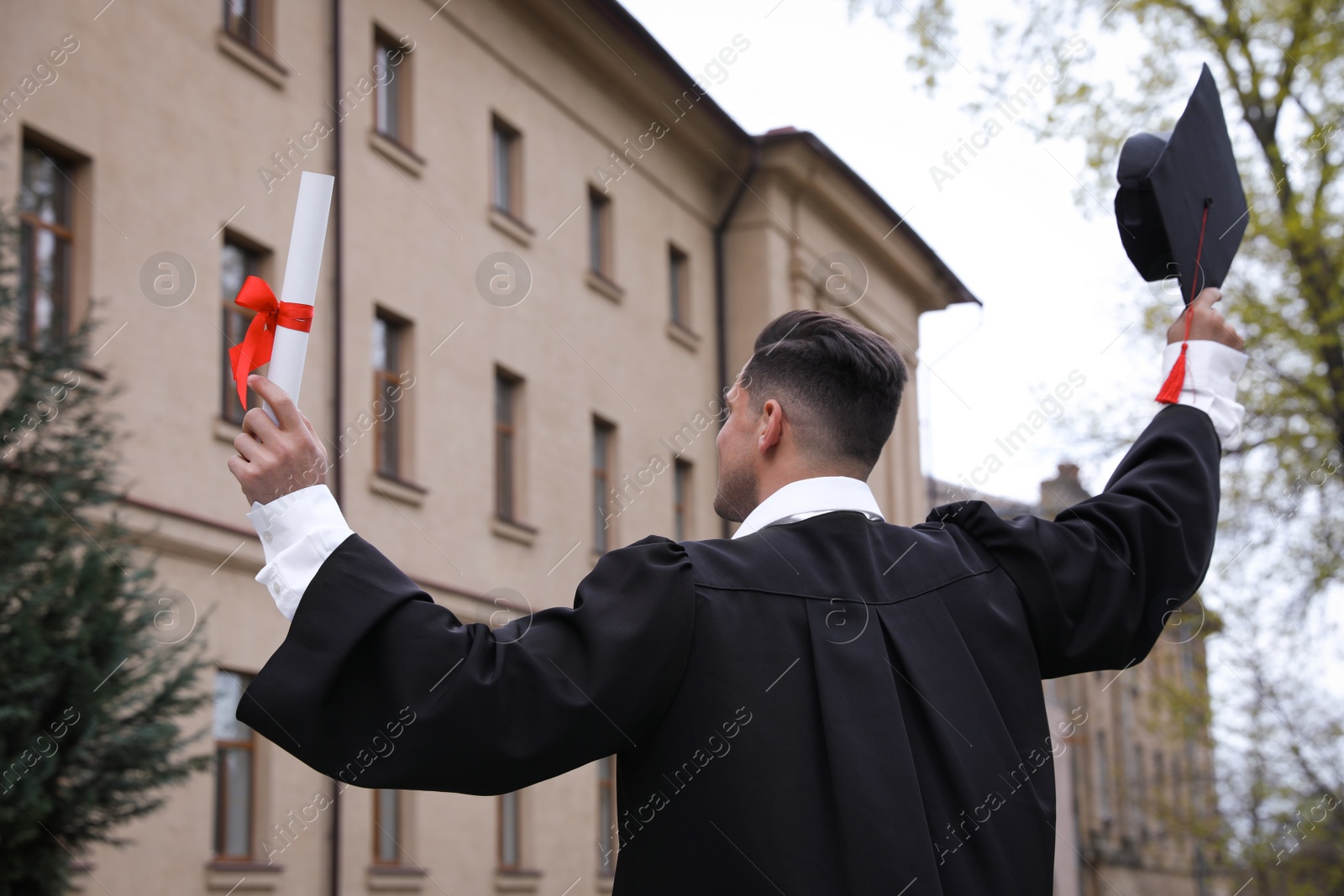 Photo of Student with diploma after graduation ceremony outdoors