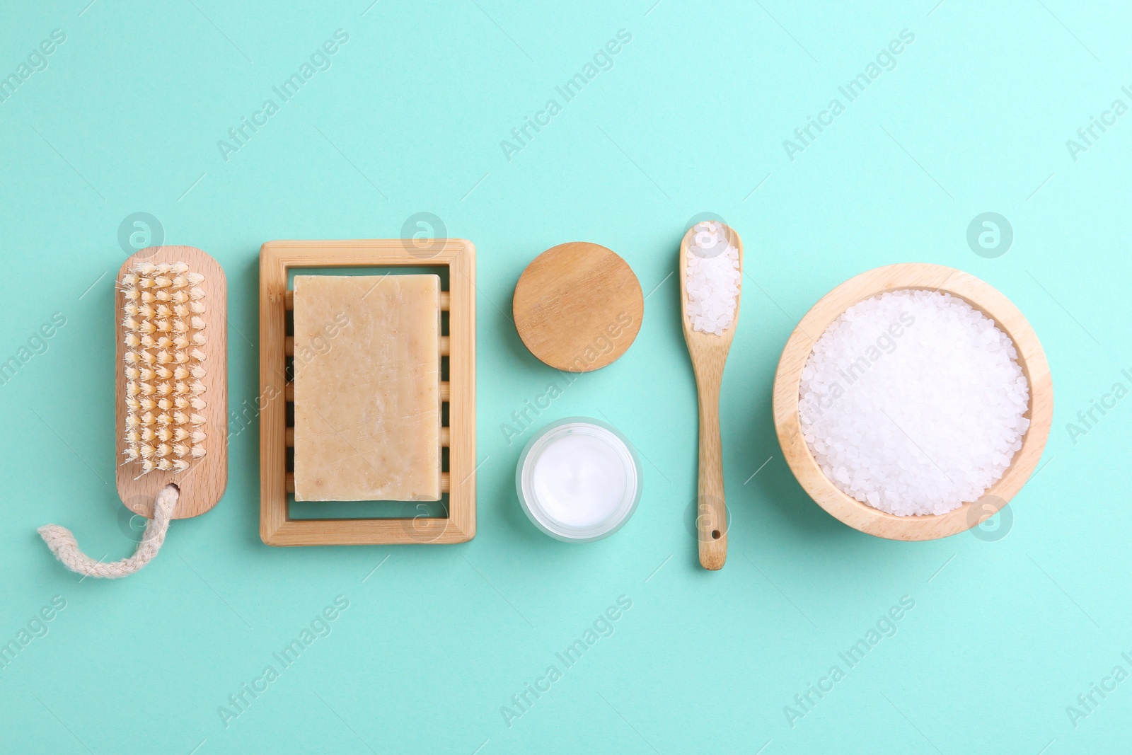 Photo of Jar of cream and body care products on turquoise background, flat lay