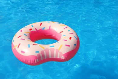 Inflatable ring floating in swimming pool on sunny day