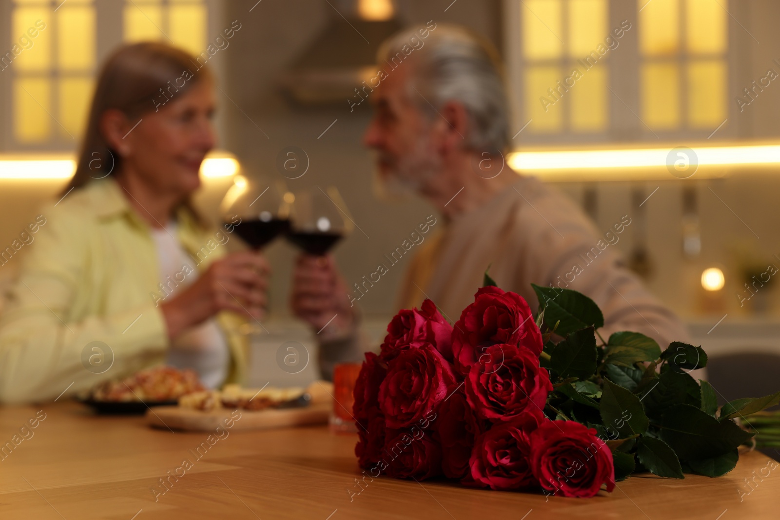 Photo of Affectionate senior couple having romantic dinner at home, selective focus