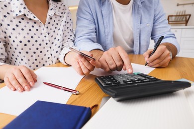 Young couple discussing family budget in kitchen, closeup