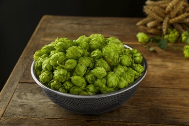 Photo of Fresh green hops in sieve wooden table