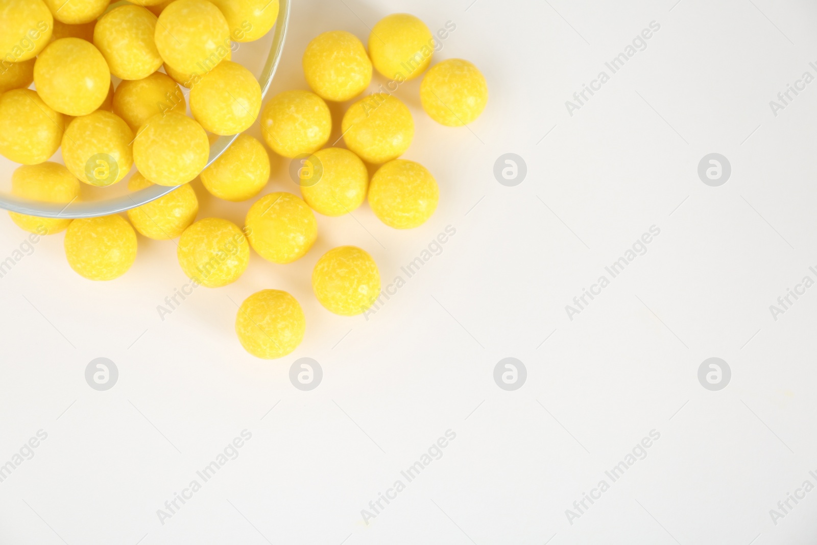 Photo of Tasty lemon drops on white background, top view