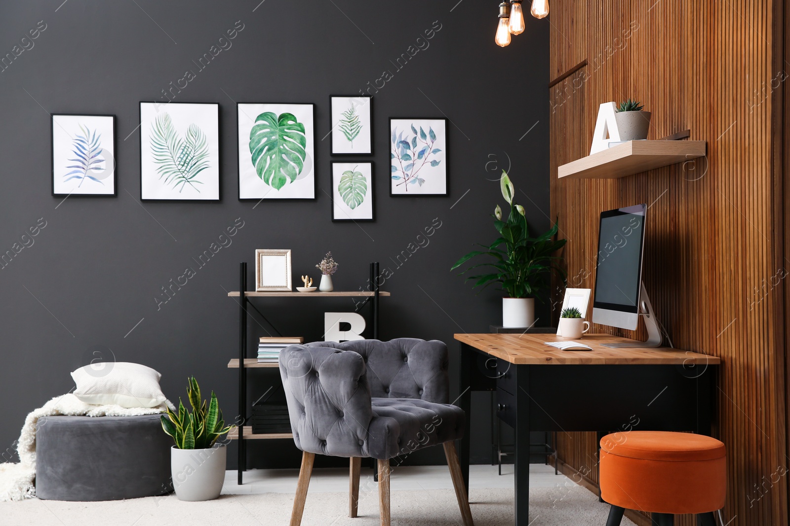 Photo of Comfortable workplace with computer near wooden wall in stylish room interior. Home office design