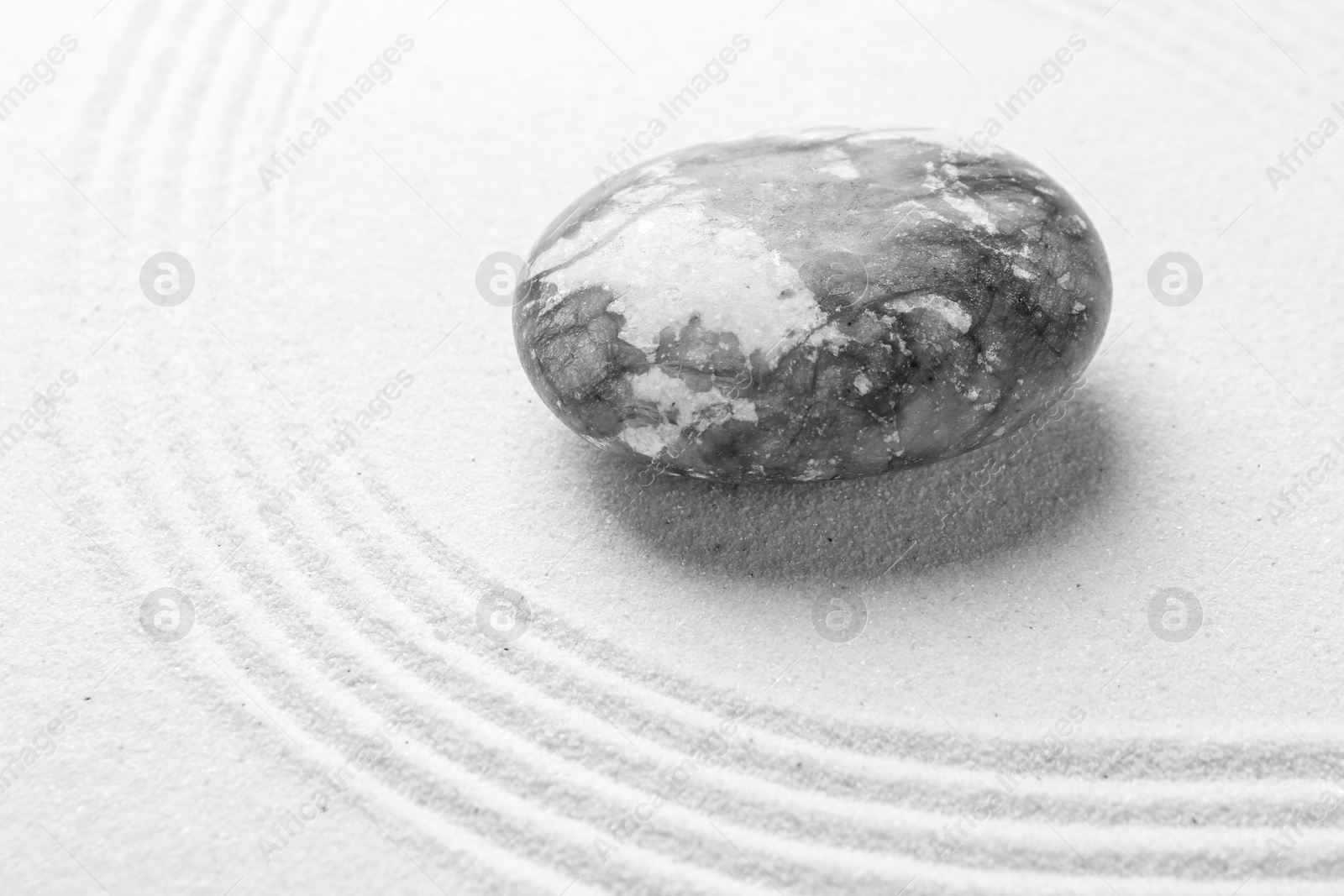 Photo of Stone on sand with pattern. Zen concept