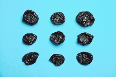 Photo of Flat lay composition with tasty prunes on color background. Dried fruit as healthy snack