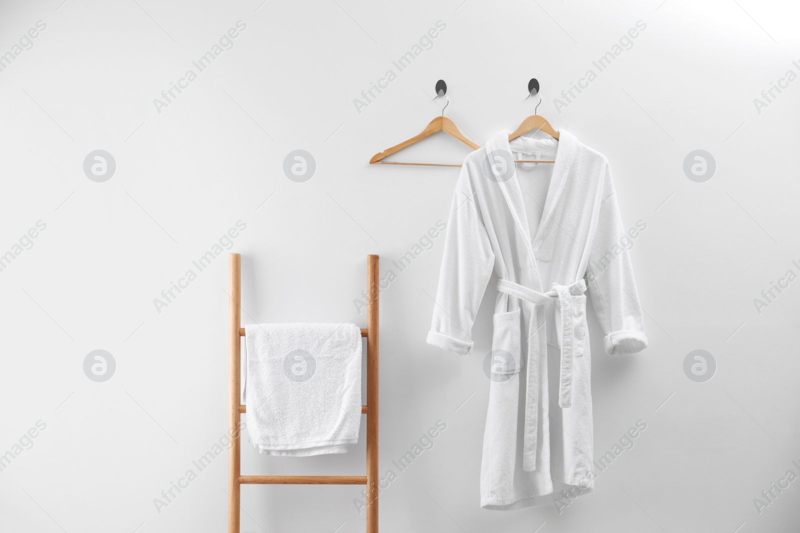 Photo of Soft comfortable bathrobe and fresh towel indoors