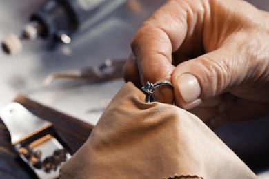 Photo of Professional jeweler working with ring, closeup view