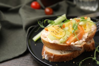 Photo of Tasty vegan sandwich with tomatoes, celery and microgreens on wooden table, closeup. Space for text