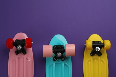 Photo of Skateboards on purple background, flat lay. Space for text