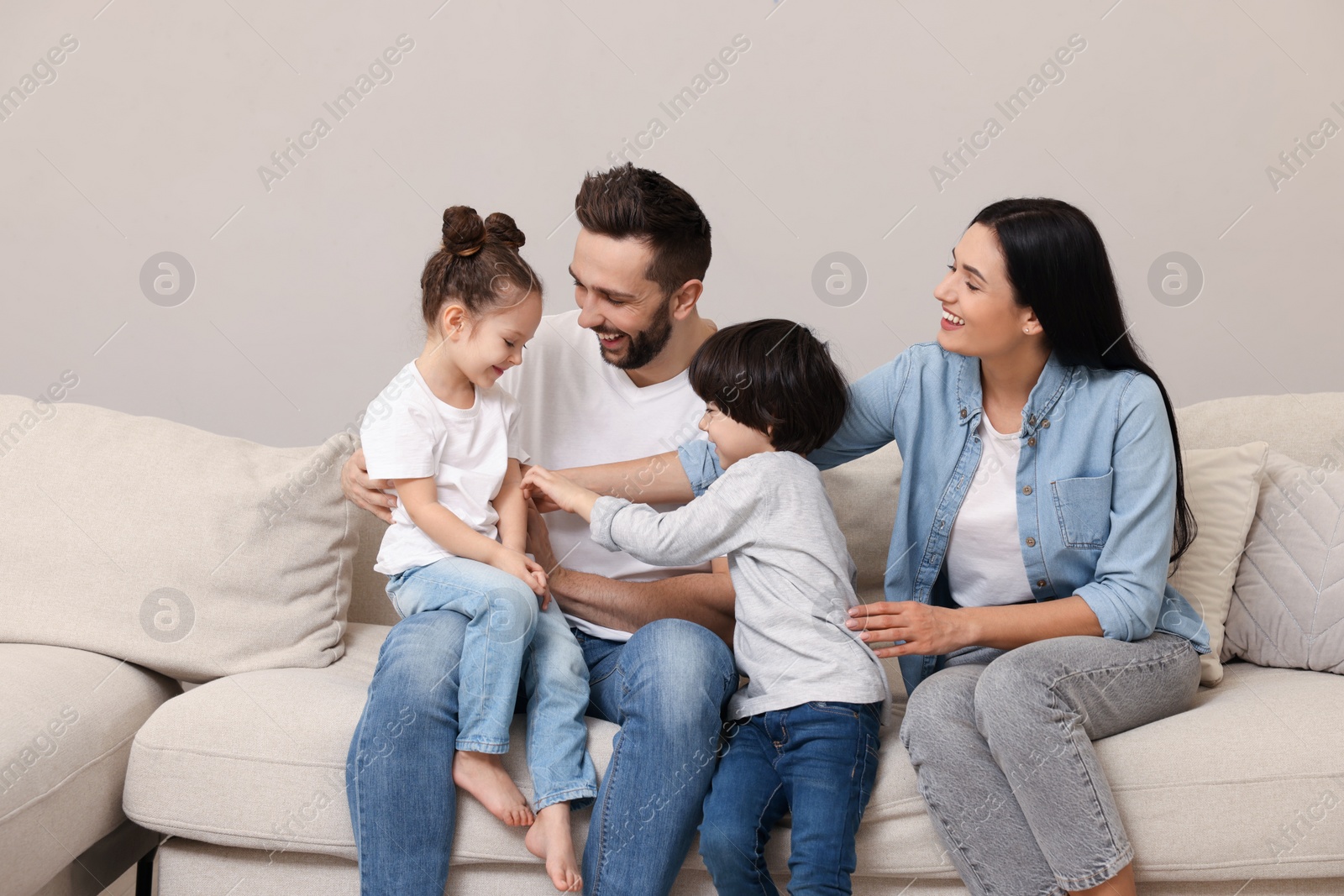 Photo of Happy family resting on sofa in living room