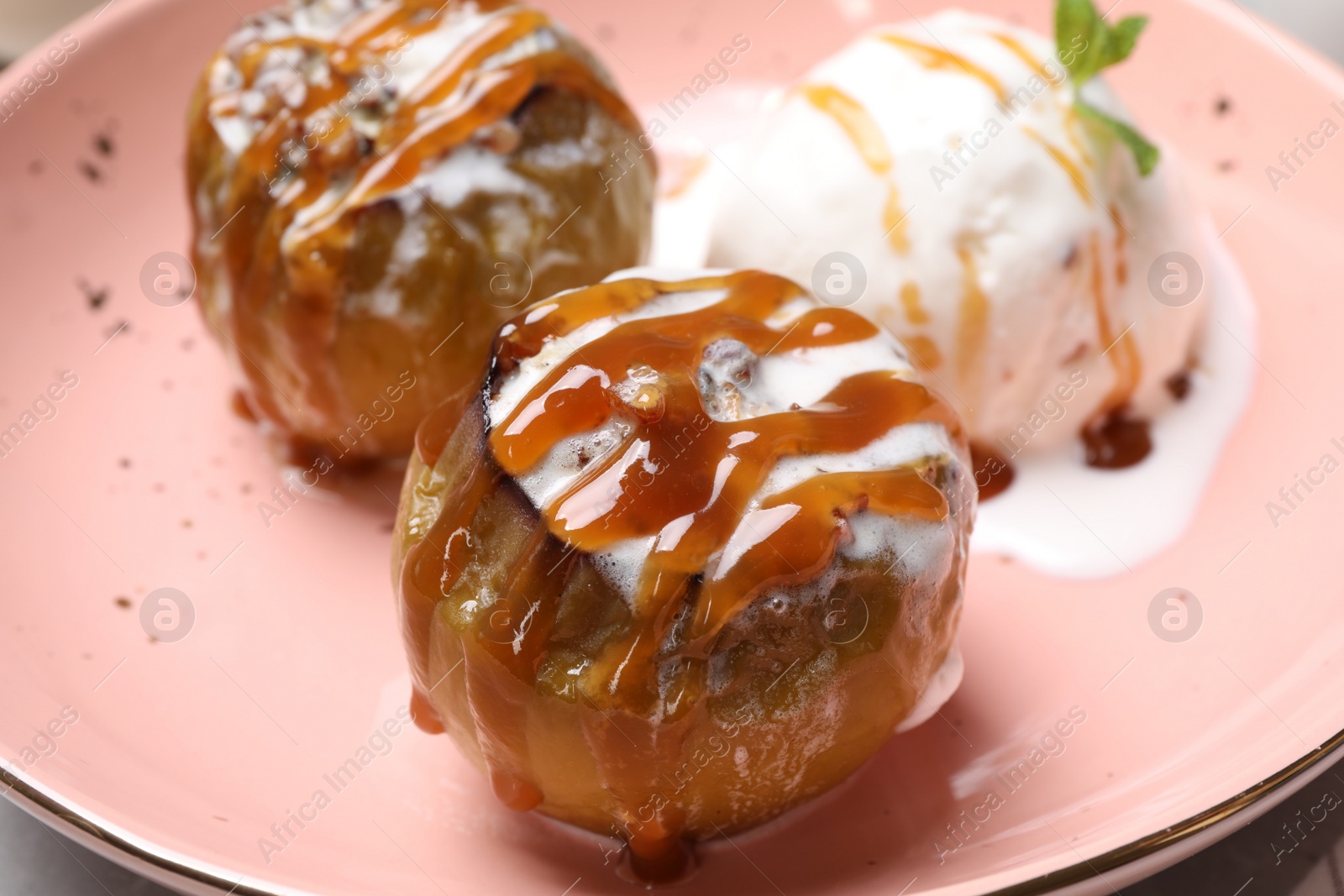 Photo of Delicious baked apples with nuts, ice cream and caramel on plate, closeup