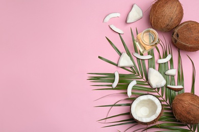 Flat lay composition with ripe coconuts, natural organic oil and space for text on pink background