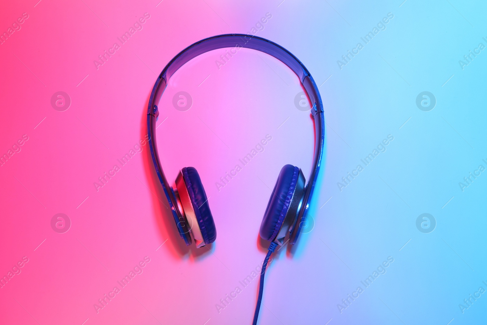 Photo of Stylish headphones on color background, top view