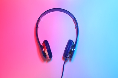 Stylish headphones on color background, top view