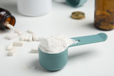 Photo of Measuring scoop of amino acids powder on white table