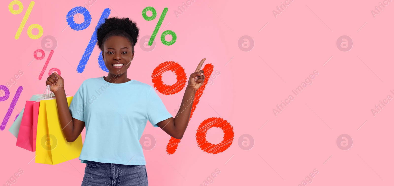 Image of Discount offer, banner design. Happy woman with paper shopping bags pointing at something on pink background, space for text. Drawn percent signs behind her