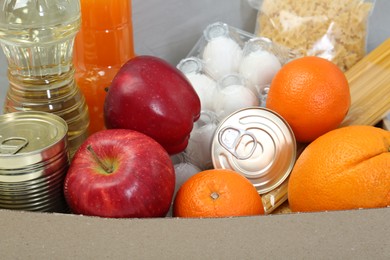 Photo of Humanitarian aid. Different food products for donation in box, closeup