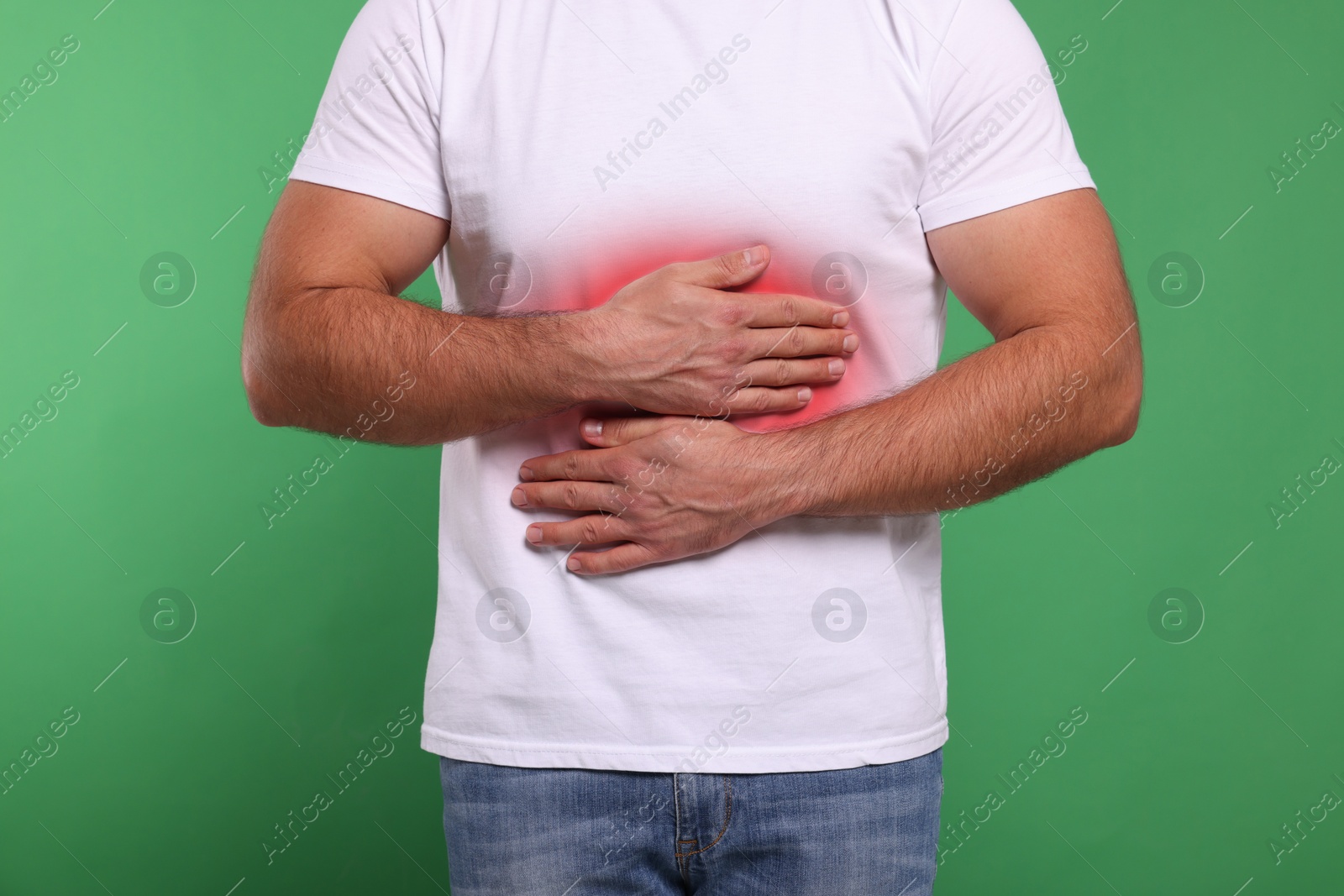 Image of Man suffering from stomach pain on green background, closeup