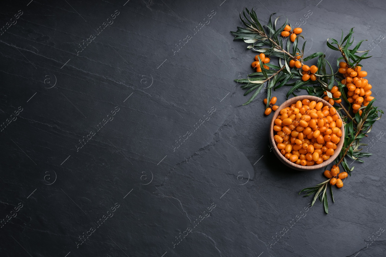 Photo of Fresh ripe sea buckthorn on black table, flat lay. Space for text