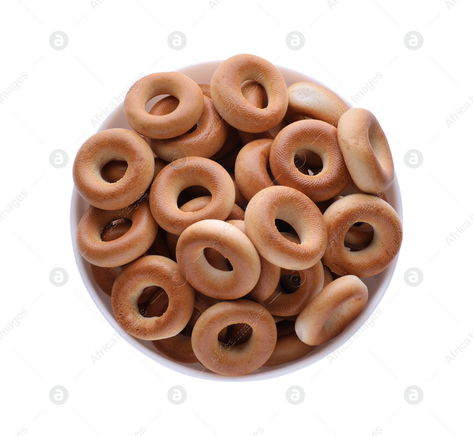 Photo of Bowl with tasty dry bagels (sushki) isolated on white, top view