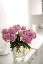 Photo of Vase with bouquet of beautiful pink peonies in kitchen