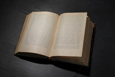 Photo of One open hardcover book on black table