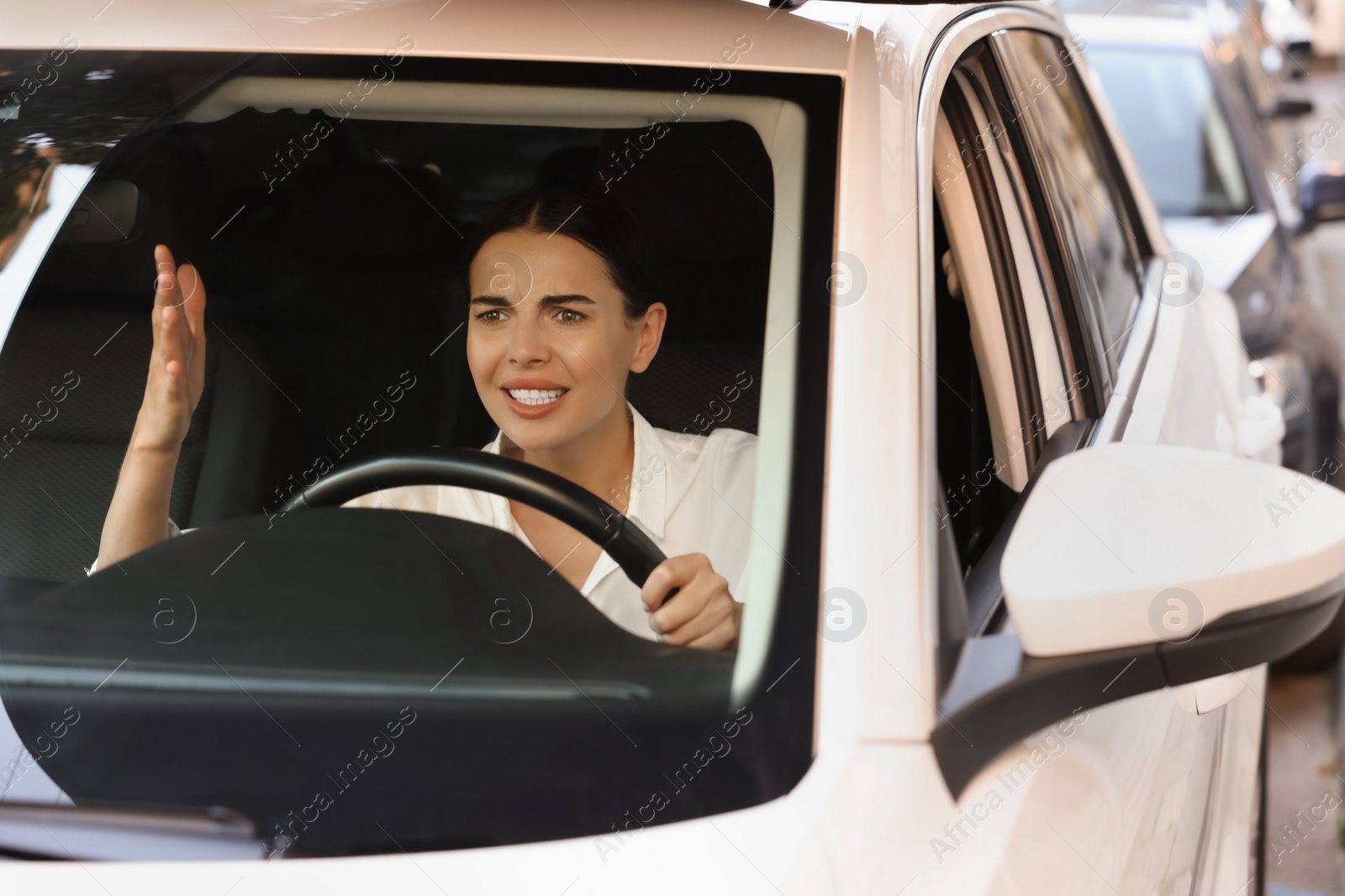 Photo of Stuck in traffic jam. Angry driver in her car, view through windshield