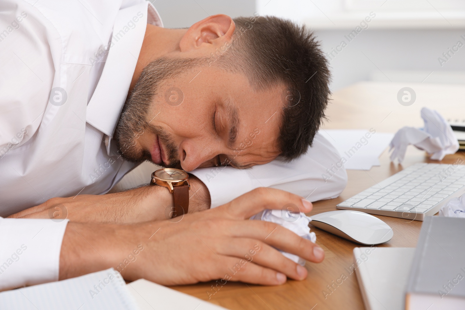 Photo of Tired man sleeping at workplace in office