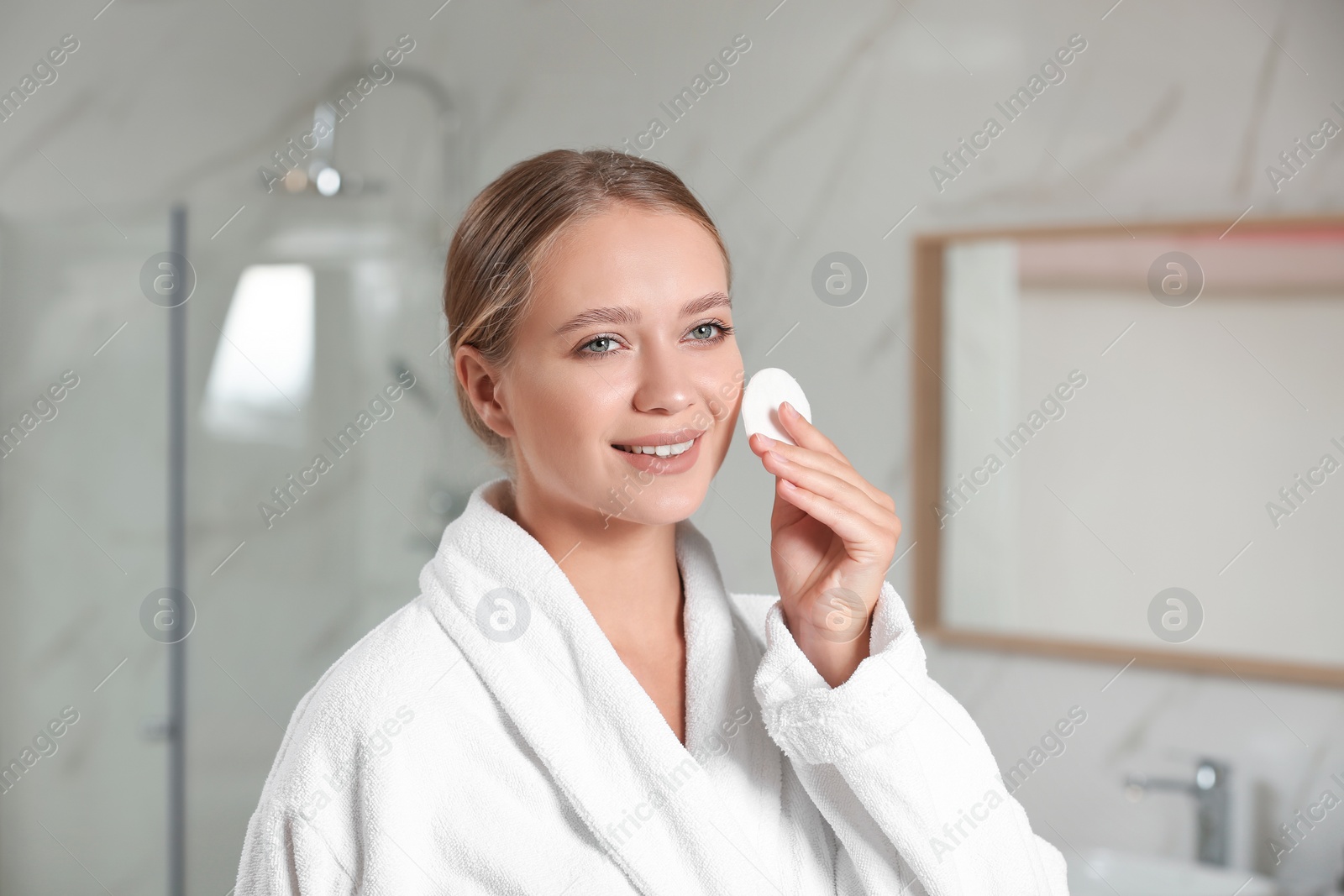 Photo of Beautiful young woman with cotton pad indoors