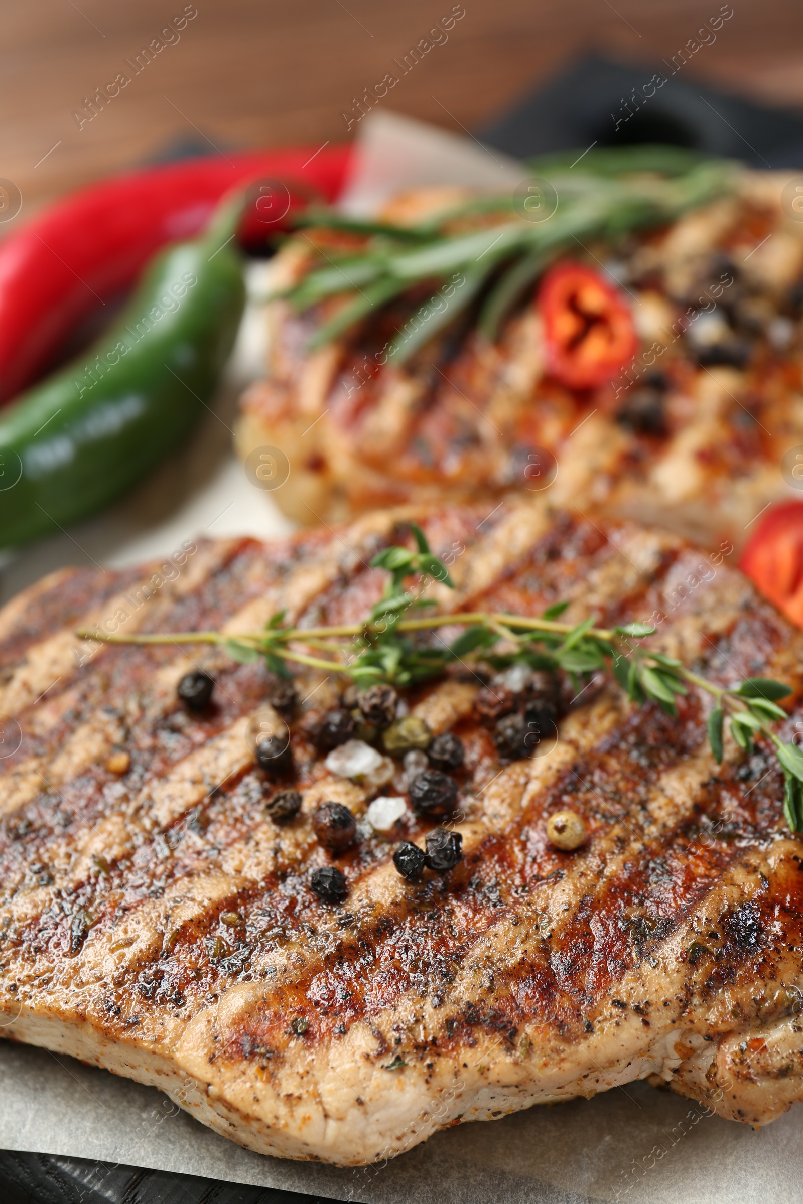 Photo of Delicious grilled pork steaks with spices on table, closeup