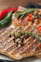 Photo of Delicious grilled pork steaks with spices on table, closeup