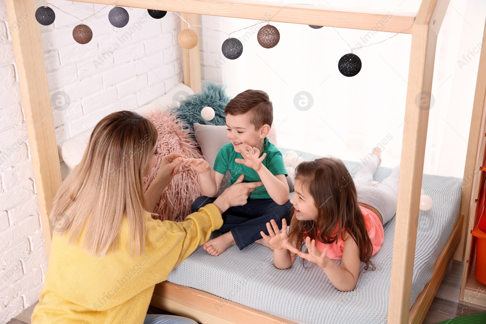 Photo of Nanny and little children playing at home