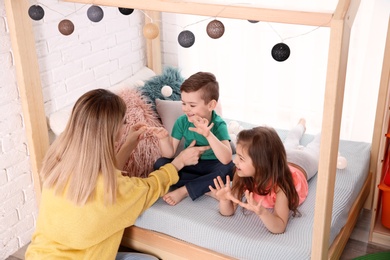 Nanny and little children playing at home