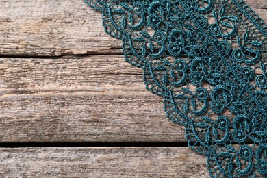 Photo of Beautiful lace on wooden table, top view. Space for text