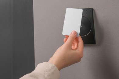 Photo of Woman opening magnetic door lock with key card, closeup. Home security