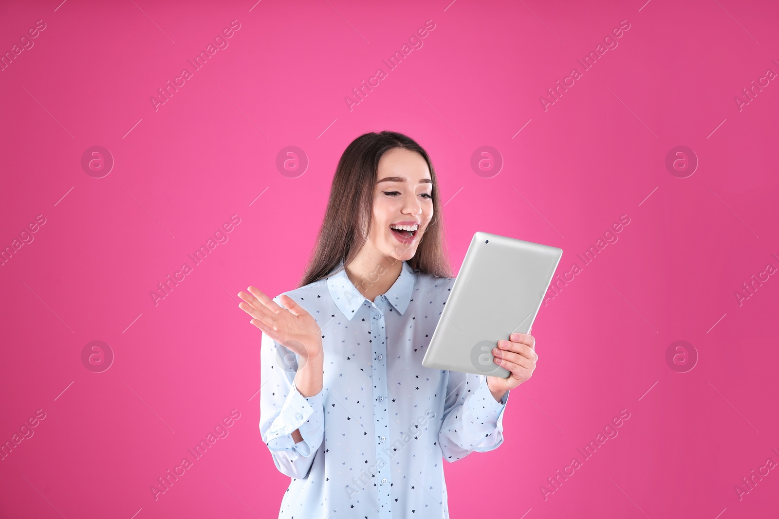 Photo of Woman using tablet for video chat on color background