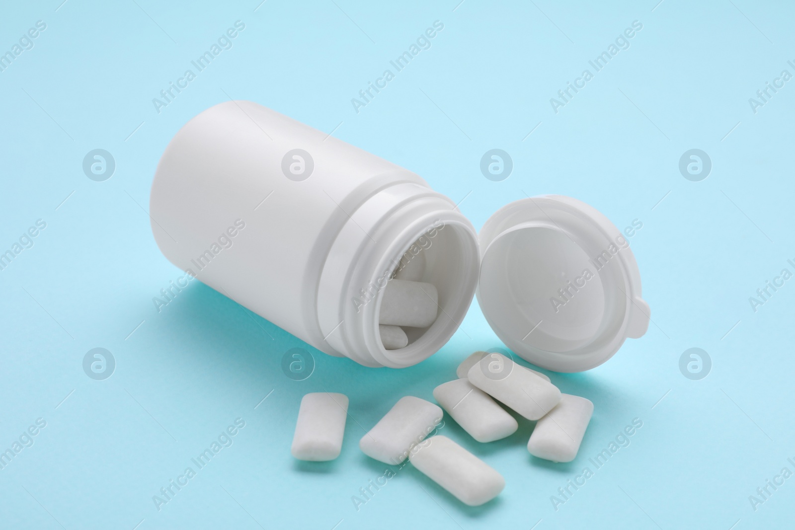 Photo of Jar with chewing gums on light blue background