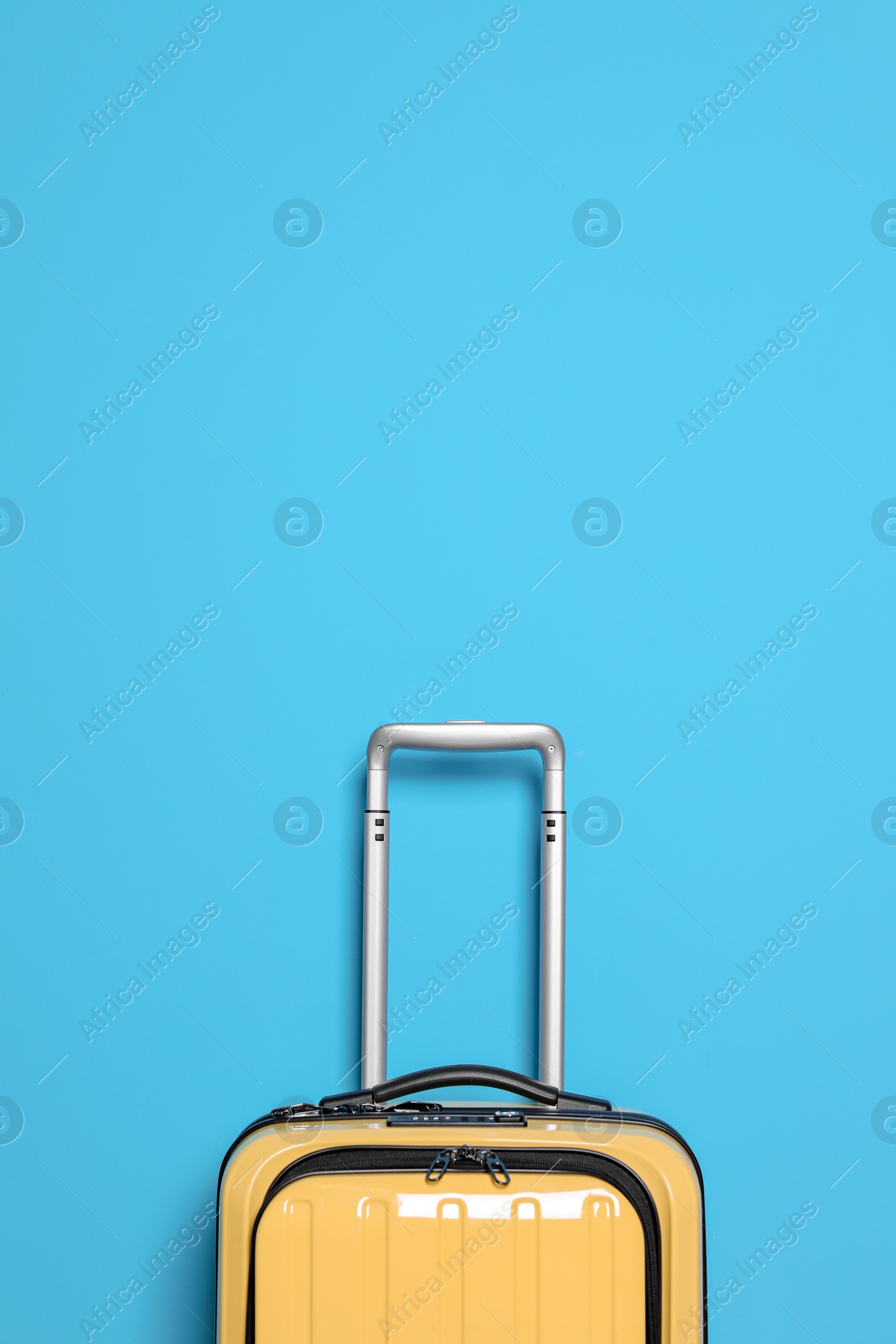 Photo of Packed bright yellow suitcase on color background