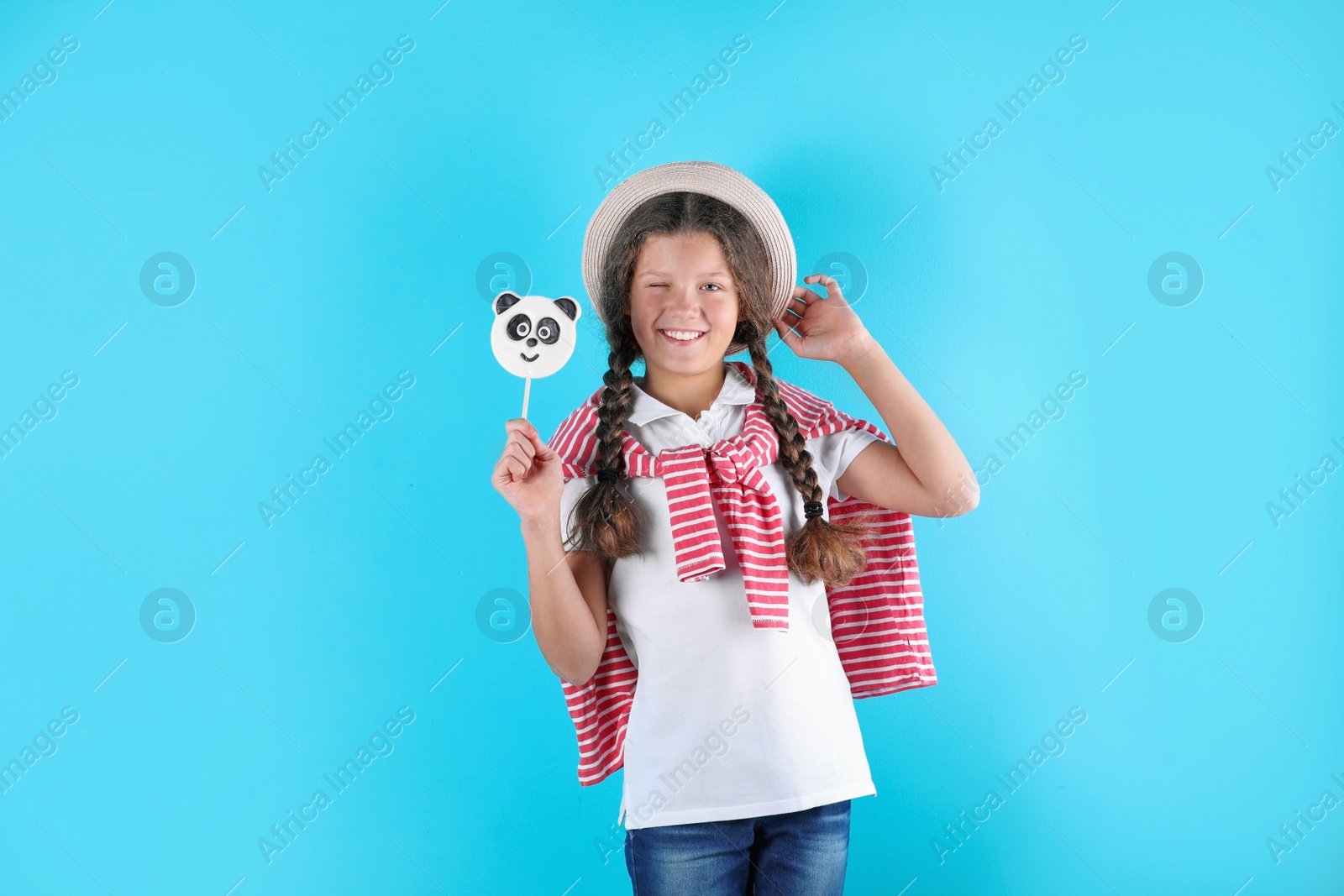 Photo of Little girl with candy on color background