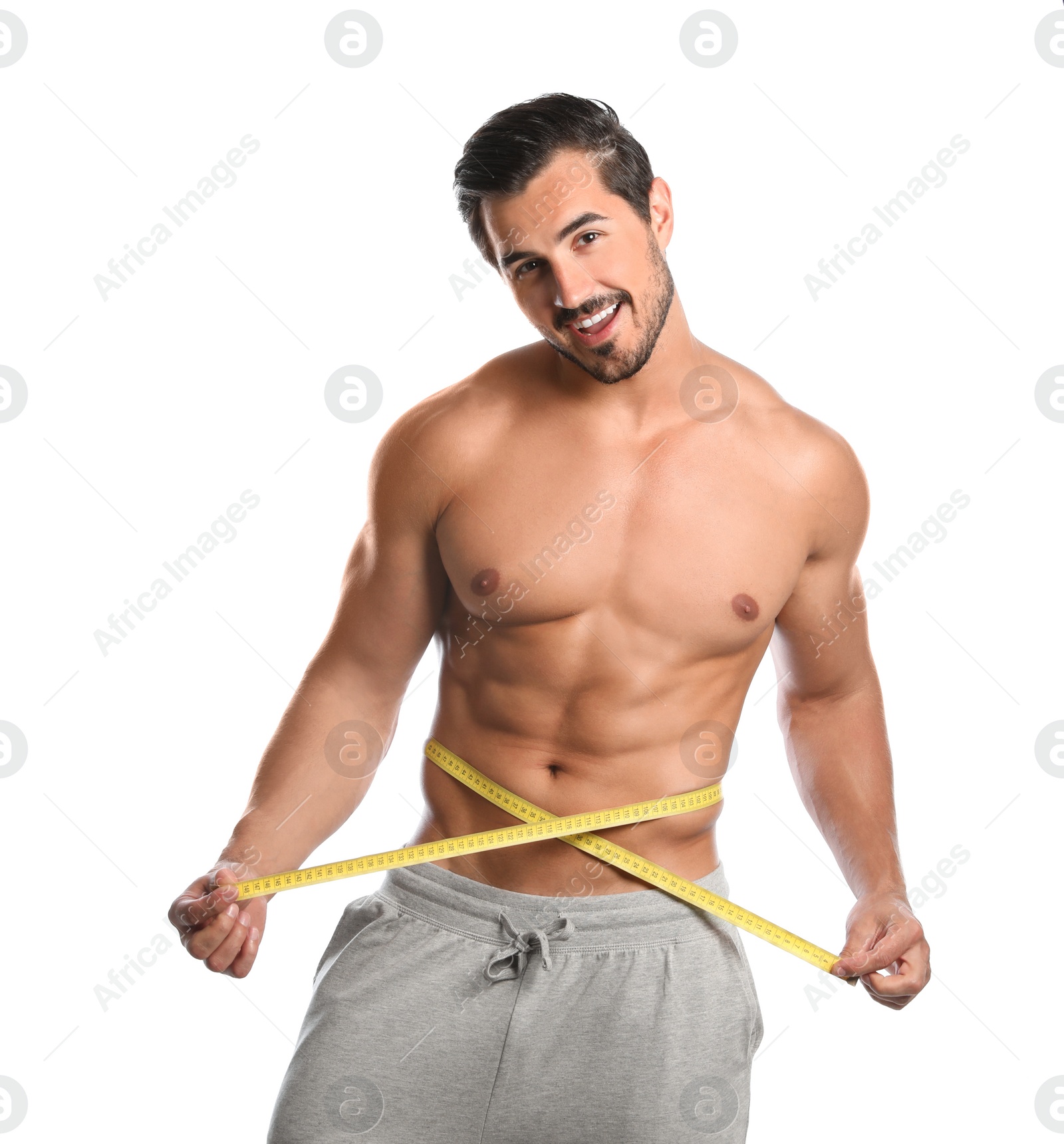 Photo of Young man with slim body using measuring tape on white background