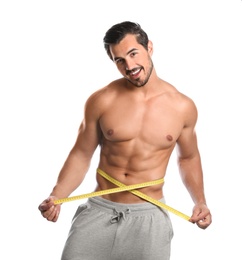 Photo of Young man with slim body using measuring tape on white background