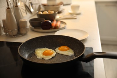 Photo of frying pan with fresh eggs on cooktop