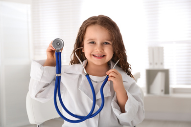 Cute little girl playing doctor in clinic