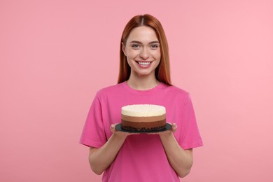 Photo of Young woman with tasty cake on pink background